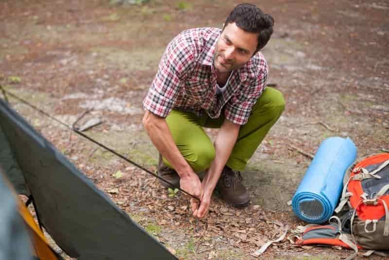 pushing tent peg into hard ground
