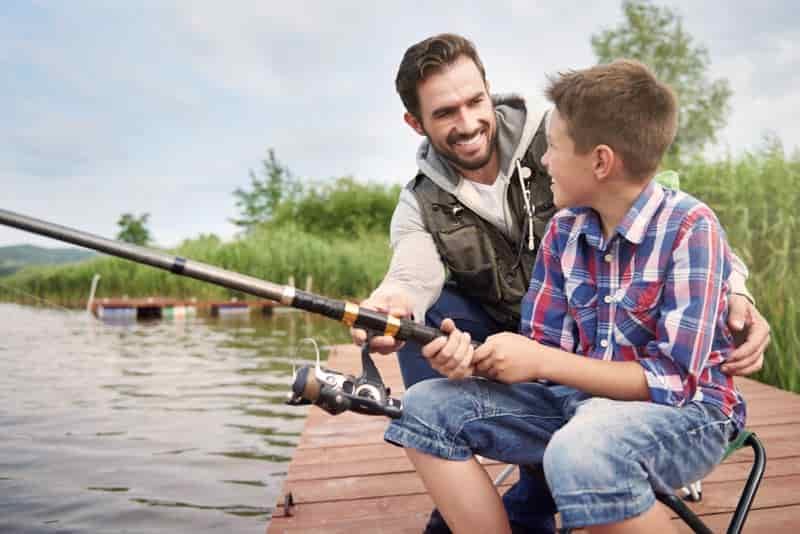 father teaching son to fish