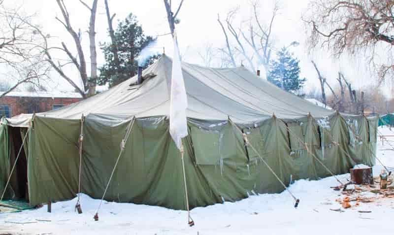 military canvas wall tent with log burner smoke